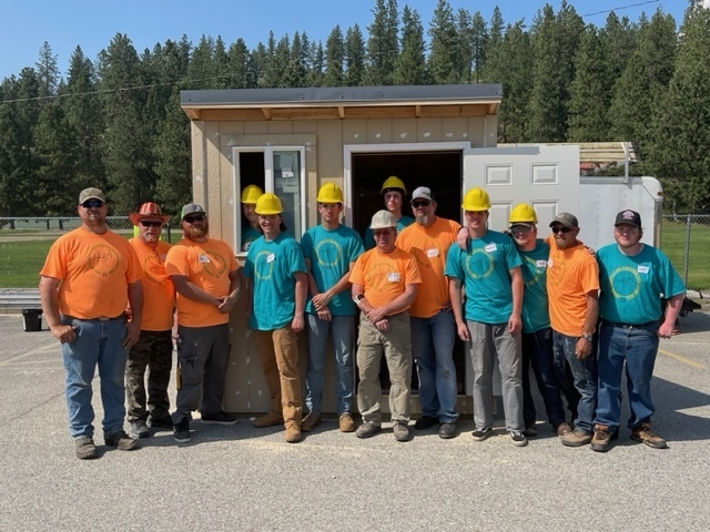 Students and builders in front of a shed they built