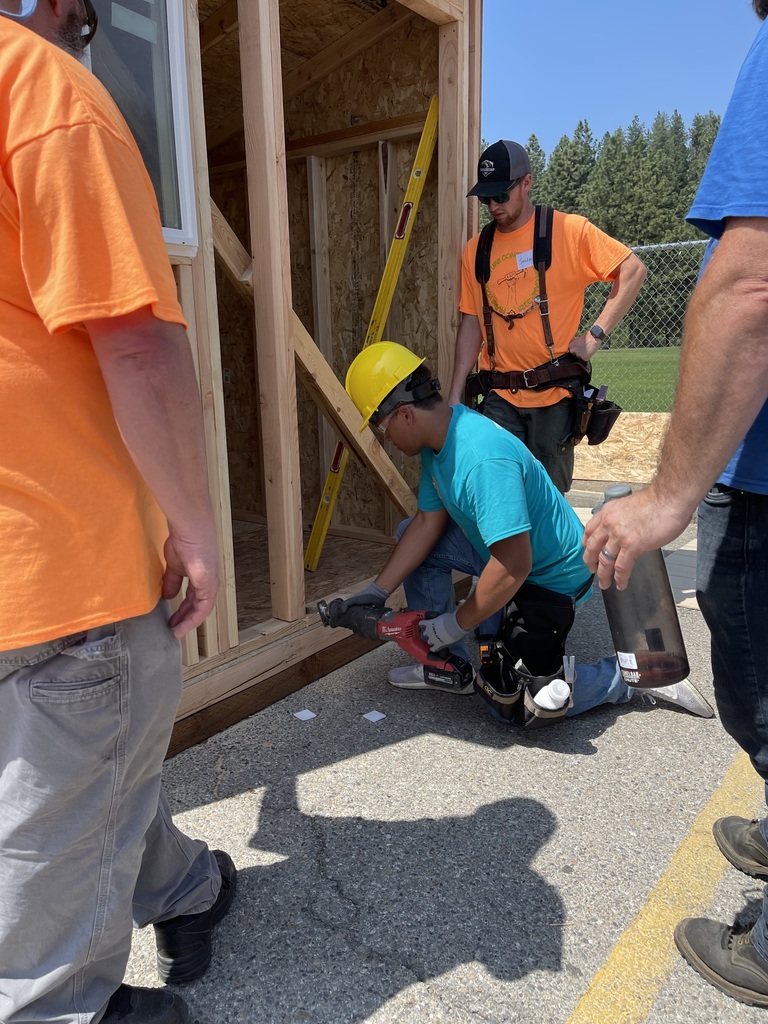 Student framing a door on a shed
