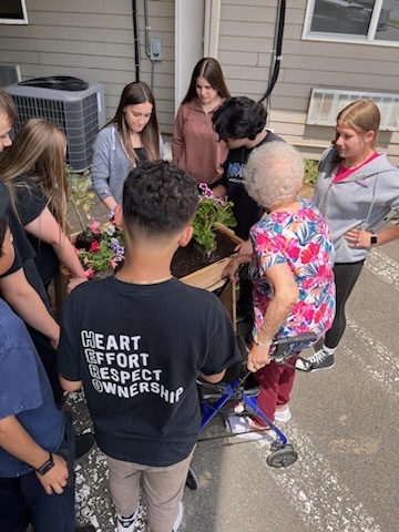 Students and senior citizens planting flowers